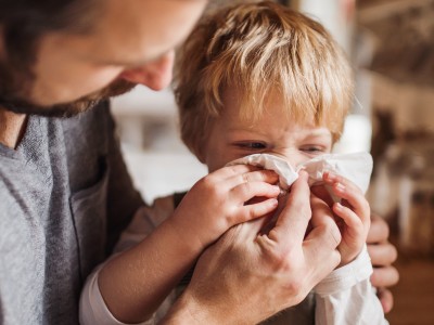 Allergien: Mann putzt einem Jungen die Nase