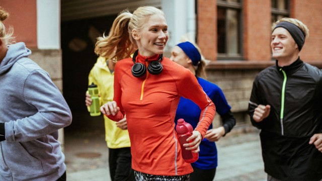 Eine Frau joggt mit Freunden in der Stadt