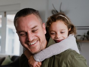 Vater trägt seine Tochter auf dem Rücken