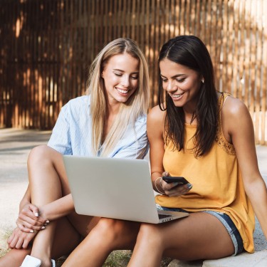 Beiträge im Blick: Zwei junge Frauen schauen auf einen Laptop